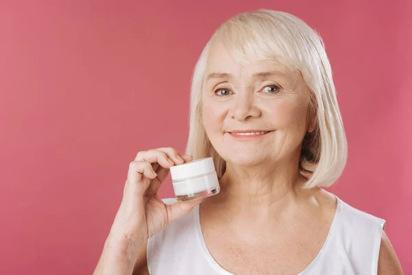 Mujer sosteniendo una crema anti edad —  Fotos de Stock