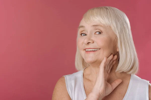 Smiling content woman touching her neck — Stock Photo, Image