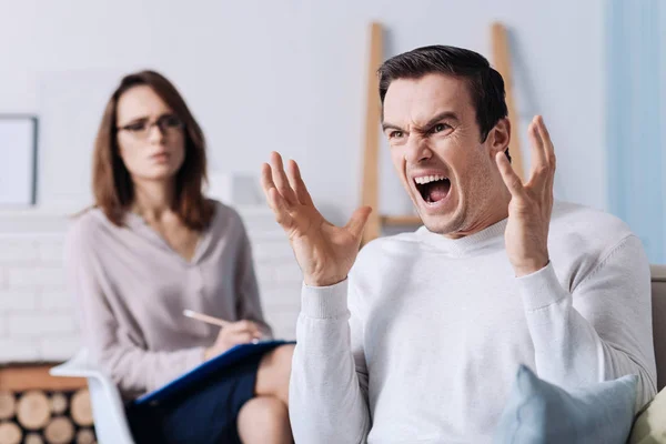Человек кричит во время консультации с психологом — стоковое фото