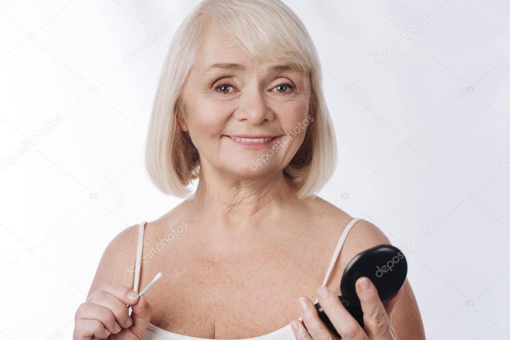 Pleasant grey haired woman looking at you