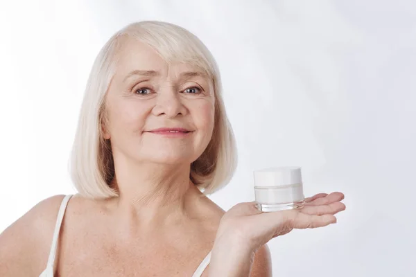 Mujer que tiene una botella de crema en la mano — Foto de Stock