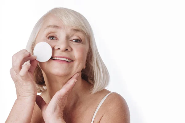 Gelukkig oudere vrouw verwijderen van haar make-up — Stockfoto