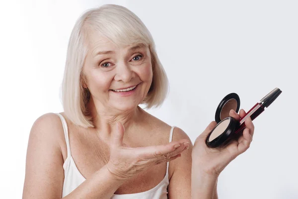 Woman holding face powder and mascara — Stock Photo, Image