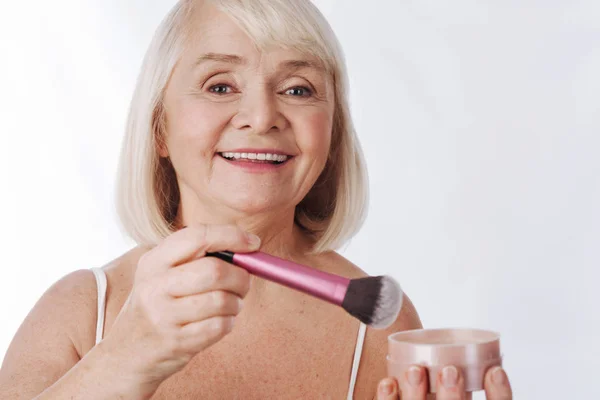 Mujer sosteniendo un cepillo de maquillaje — Foto de Stock