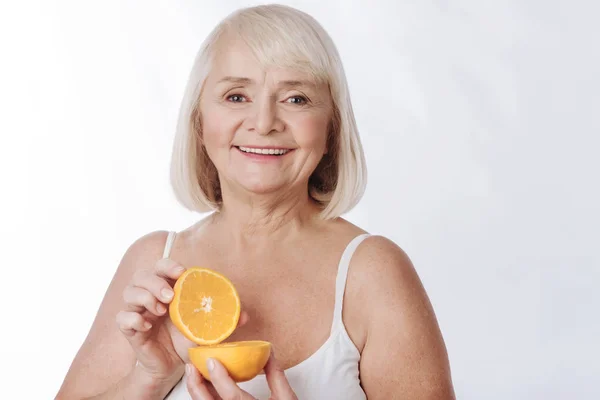 Mujer sosteniendo dos partes de naranja — Foto de Stock