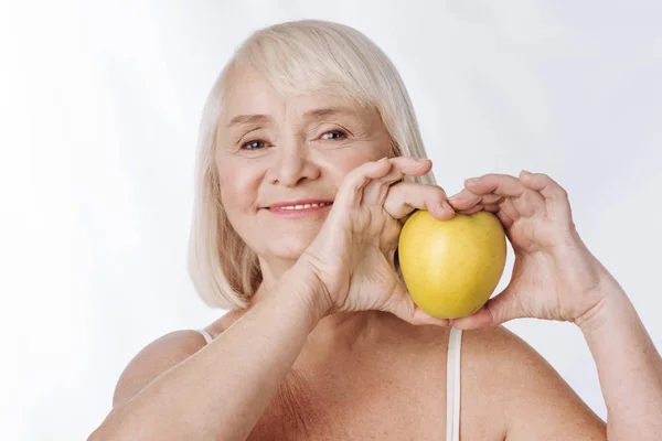 Optimistic woman with yellow apple — Stock Photo, Image