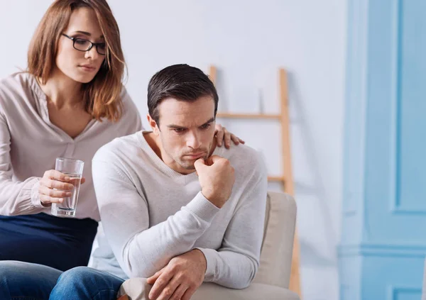 Verzweifelter Mann sitzt zu Hause bei seiner Frau. — Stockfoto