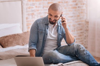 Telefonda konuşan neşeli sakallı adam