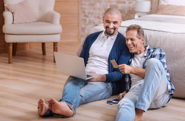 Pareja gay mirando el portátil y divirtiéndose — Foto de Stock