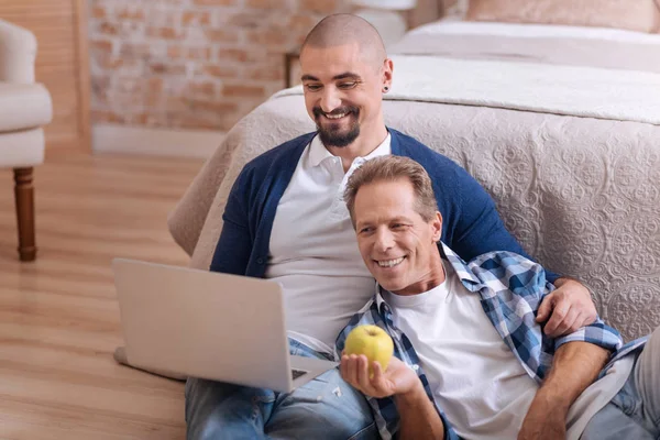 Non-traditional couple looking at the laptop and having fun — Stock Photo, Image