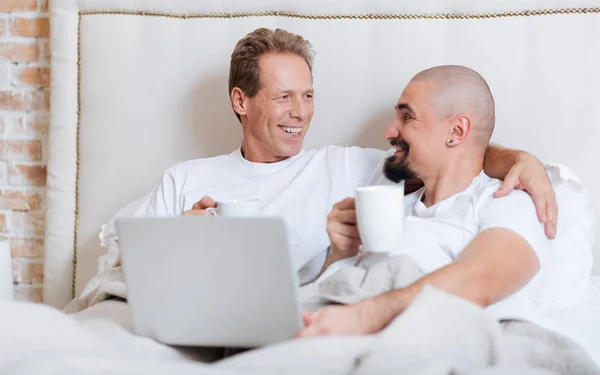 Sorrindo casal homossexual usando o laptop no quarto — Fotografia de Stock