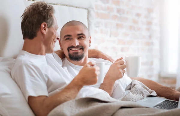 Glad homosexuella par har konversationen i sängen — Stockfoto