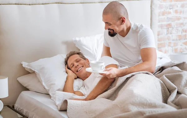 Glada homosexuella par har frukost i sängen — Stockfoto