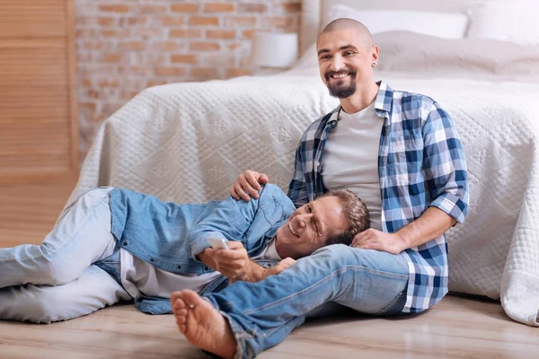 Encantada pareja gay viendo televisión juntos en casa — Foto de Stock