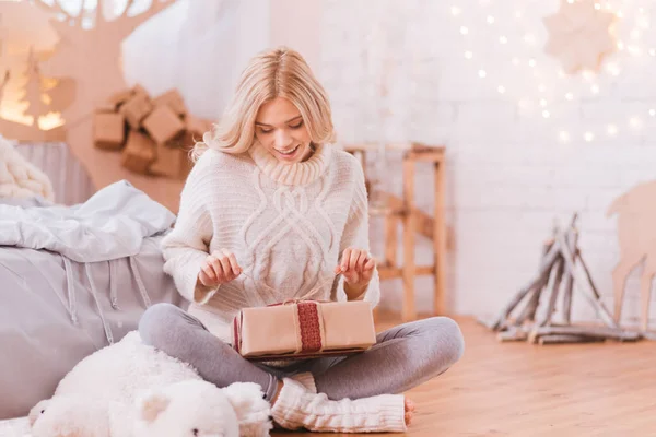 Позитивная любопытная женщина открывает рождественскую коробку — стоковое фото