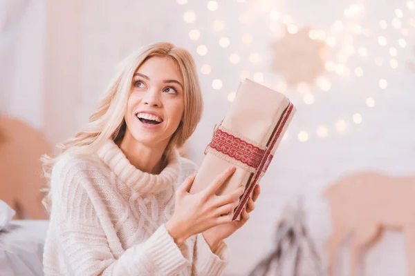 Весела допитлива жінка потискає різдвяну коробку — стокове фото