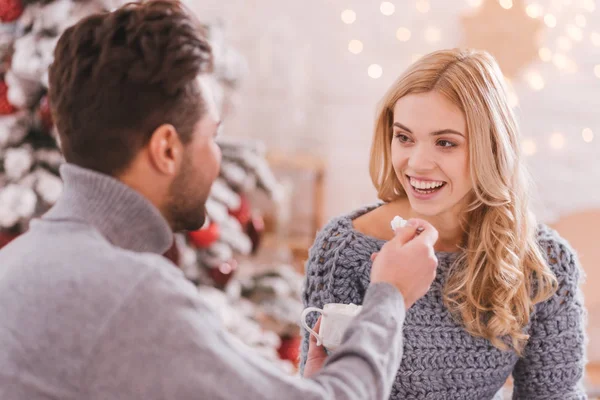 Positieve zorgzame man met een lepel met marshmallows — Stockfoto