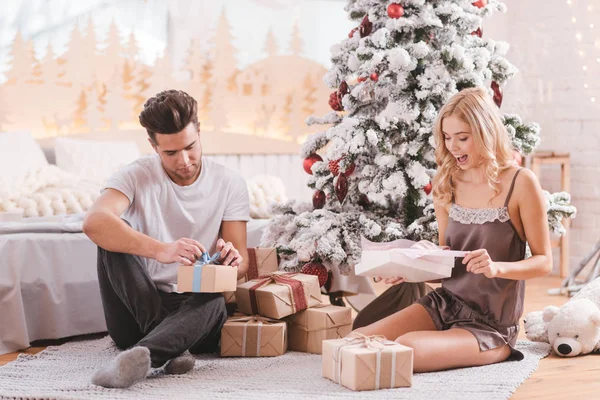 Agréable couple curieux déballer leurs cadeaux — Photo