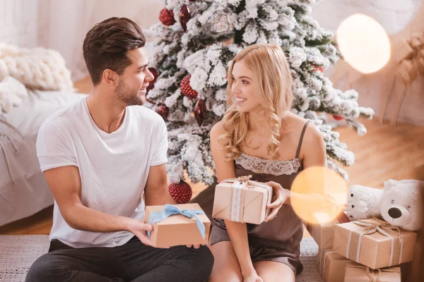 Good looking nice couple exchanging their Christmas presents — Stock Photo, Image