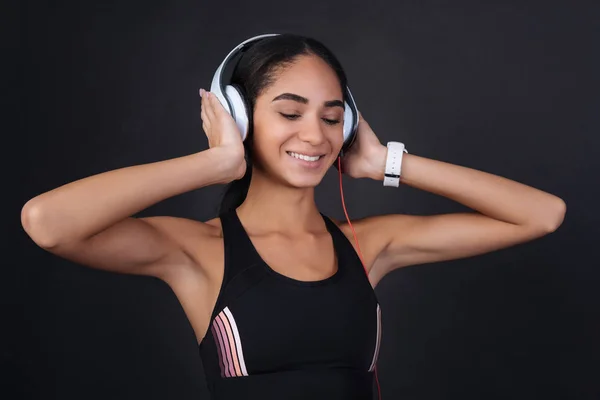 Primer plano de la chica feliz sosteniendo ambas manos en los auriculares —  Fotos de Stock