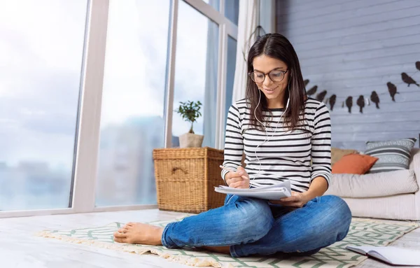 Vrouw tekenen en luisteren naar de muziek — Stockfoto