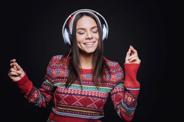 Веселая молодая женщина слушает музыку и танцует — стоковое фото
