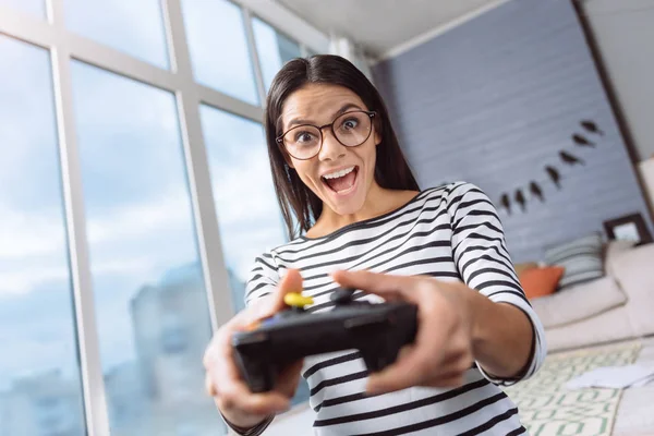 Mulher excitada jogando jogos virtuais usando um console de jogos — Fotografia de Stock