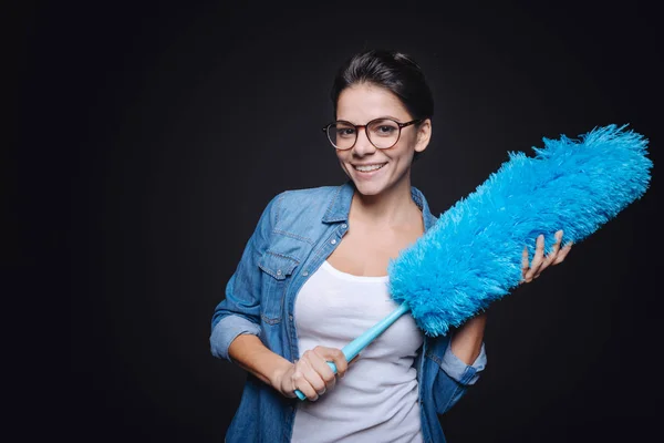 Sorrindo jovem dona de casa segurando a escova de poeira — Fotografia de Stock