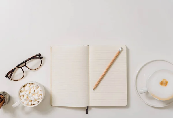 Notebook omgeven door koffie en marshmallows — Stockfoto