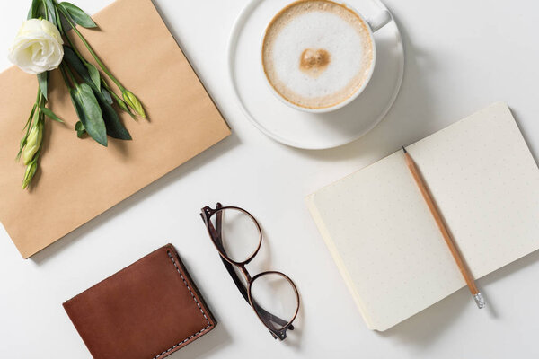 Белый цветок лежит на конверте
