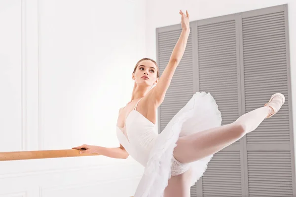 Junge Ballerina hält Arm und Bein in der Luft — Stockfoto