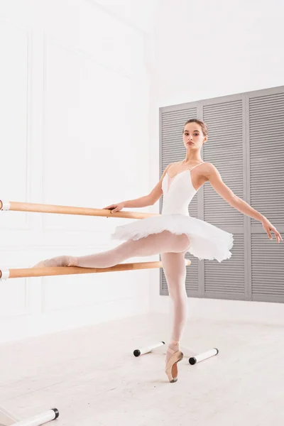 Sporty young woman holding her leg upwards — Stock Photo, Image