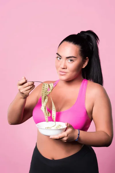 Mulato mujer sosteniendo plato con cinta métrica — Foto de Stock