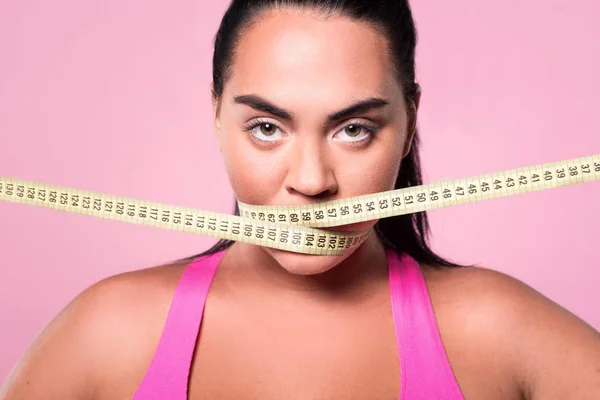 Close-up of mulatto woman covering mouth with measuring tape — Stock Photo, Image