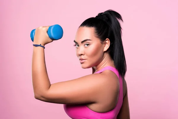 Side view of chubby mulatto woman holding dumbbell — Stock Photo, Image