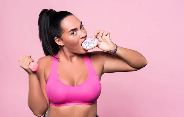 Mollige vrouw donut eten tijdens het sporten — Stockfoto