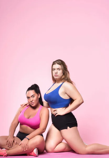 Two chubby female friends on pink background — Stock Photo, Image