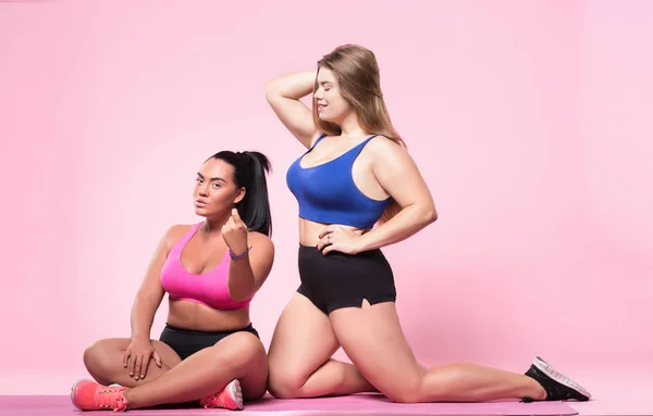 Two plump woman posing on pink background — Stock Photo, Image