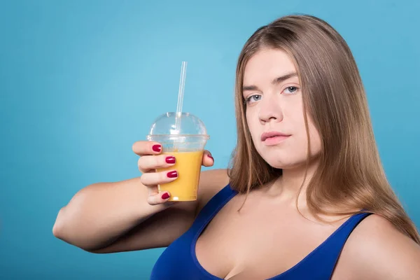 Unga knubbig lady anläggningen juice — Stockfoto