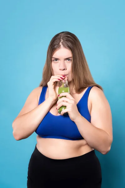 Mujer regordeta bebiendo bebida verde — Foto de Stock