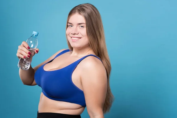 Досить надмірна вага леді тримає пляшку води — стокове фото