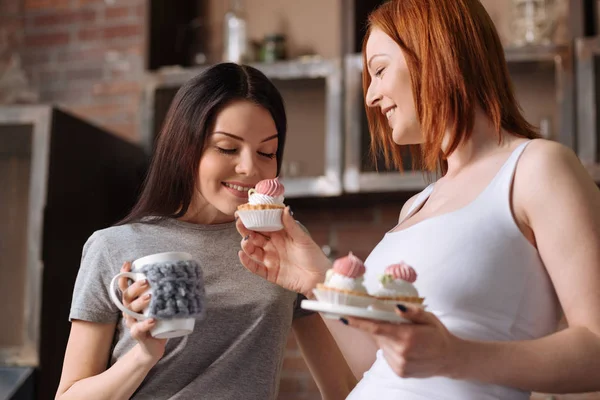 Glada attraktiva kvinnor lukta dessert — Stockfoto