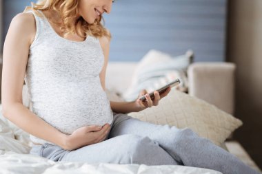 Hamile kullanarak yakın smartphone yatakta