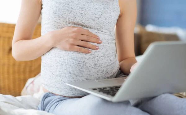 妊娠中の女性の寝室でラップトップを使用してのクローズ アップ — ストック写真