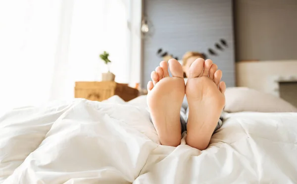 Close up of pregnant womans feet lying in bed — Stock Photo, Image