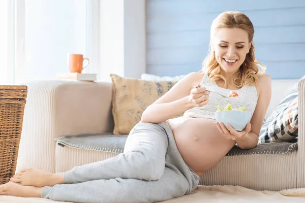 Donna incinta mangiare insalata nella sua stanza — Foto Stock