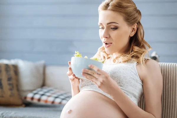 Mulher grávida segurando um prato com salada — Fotografia de Stock