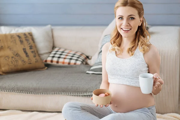 Femme enceinte dégustant du thé aux macarons — Photo