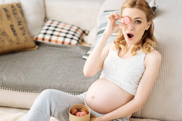 Embarazada alegre mujer divirtiéndose con macarrones — Foto de Stock