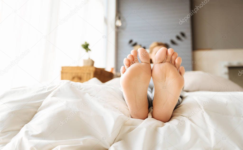Close up of pregnant womans feet lying in bed